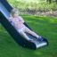 Bambina che gioca sullo scivolo di Romping Center Nature in un giardino.