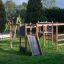 Gorilla Nature struttura da gioco in legno con scivoli e strutture per arrampicarsi in un parco verde.