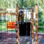 Bambino che si arrampica sulla struttura da gioco in legno Gorilla Nature all'aperto.