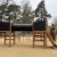 Casetta da gioco in legno Motor Function Center Nature con strutture per arrampicarsi e scivolo in un'area giochi all'apert