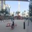 Bambini che giocano su un Double Seesaw rosso in un moderno parco giochi urbano.