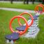 Double Seesaw in un parco giochi con maniglie rosse e base a molla.