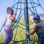 Due bambini che scalano su Powerclimber climbing net all'aperto.