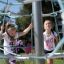 Bambini che giocano all'aperto su un Powerclimber climbing net.