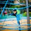 Bambino che si arrampica su Powerclimber climbing net nel parco giochi.