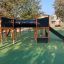 Attrezzatura da parco giochi Square Play Nature con uno scivolo e una struttura per arrampicarsi in un parco.