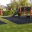 Attrezzatura da parco giochi in legno Square Play Nature con scivolo e strutture per arrampicarsi in un giardino