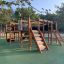 Parco giochi in legno Square Play Nature con scivoli, strutture per arrampicarsi e tunnel per bambini.