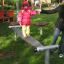 Bambino in equilibrio sull'attrezzatura da gioco Surf Board con il supporto di un genitore.