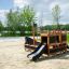 Struttura in legno Small Ship Nature con scivolo su terreno sabbioso nel parco.