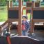 Bambino che gioca sull'attrezzatura da parco giochi all'aperto Small Ship Nature.