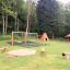 Sandbox with bark in un parco giochi circondato da alberi e panchine.