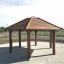 Gazebo in legno da esterno Firehouse con struttura del tetto a doghe su una base di ghiaia.