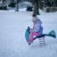 Bambino che gioca su un gioco a molla Yacht Swing rocking in un parco giochi innevato