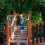Tritowers Nature castle with slide struttura da gioco in legno con bambino che sale le scale