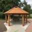 Gazebo in legno Long Firehouse con panchine in un parco.