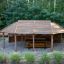Long Firehouse gazebo in legno all'aperto con tavolo da picnic in un ambiente boschivo