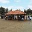 Gazebo in legno chiamato Long Firehouse in un parco, circondato da persone