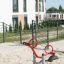 Moderne attrezzature da gioco rosse SeeSaw in un'area giochi sabbiosa.
