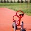 Attrezzatura da parco giochi rossa SeeSaw su pavimentazione in gomma per esterni.