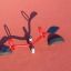 Attrezzature da gioco rosse SeeSaw con sedili neri su una superficie morbida rossa.