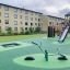 SeeSaw in un moderno parco giochi con scivoli e strutture per arrampicarsi.
