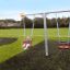 Baby Double Swing in un parco giochi con un bambino che si diverte su di esso.