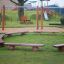 Firepit seating panchine in legno disposte in cerchio sull'erba del parco giochi