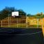 Campo sportivo all'aperto con canestro da basket e recinzioni gialle Santiago Bernabeu.