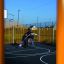 Bambini che giocano a basket sul parco giochi Santiago Bernabeu con attrezzature colorate sullo sfondo.