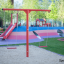 Youth Double Swing in un parco giochi con attrezzature colorate.