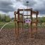 Sherwood wooden playhouse in un parco circondato da alberi.