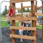 Bambini che giocano su Sherwood wooden playhouse.
