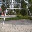 Silver Double Swing in un parco giochi con sabbia e attrezzature del parco nelle vicinanze.