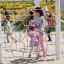 Una madre e una figlia che giocano su una struttura di casetta in legno in un parco giochi.