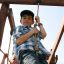 Bambini che giocano su Yellowstone wooden playhouse.