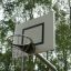 Canestro da basket all'aperto in un parco con alberi sullo sfondo.
