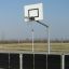 Canestro da basket all'aperto con recinzione metallica nera in un'area sportiva.