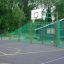 Campo da basket all'aperto con recinzioni metalliche verdi, con l'impianto da basket Shea.