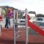 Bambini che giocano su Junior single slide con struttura da arrampicata.