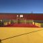 Parco giochi Maracana con superfici rosse e gialle, completo di campo da basket e recinzioni di sicurezza i