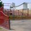 Campo da basket rosso Olimpico con recinzione metallica.