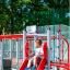 Bambino che gioca sullo scivolo Sword fish steel structure in un parco giochi.