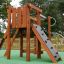 Stranda wooden playhouse con parete da arrampicata e scivolo in un parco giochi.