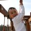 Un bambino che gioca su Kampinos wooden playhouse.