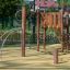 Struttura da arrampicata in legno per parco giochi Alv con rete di corda e scivolo in un parco.