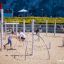 Bambini che giocano sulle attrezzature da parco giochi Alv con corde e pali per arrampicarsi in un'area giochi sabbiosa.