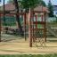 Attrezzatura da parco giochi per bambini Alv con scivolo e reti da arrampicata in un parco.