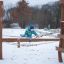 Bambino che gioca su un ponte di corda in un parco giochi all'aperto durante l'inverno.