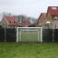 Porta da calcio con pannelli neri installata in un'area residenziale.